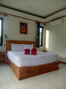 a bedroom with a large bed with two red pillows at Lanta Buddy Resort in Ko Lanta