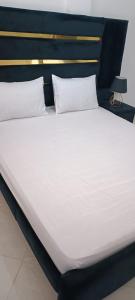 a large bed with white sheets and pillows at Le Nid d'azrou in Azrou