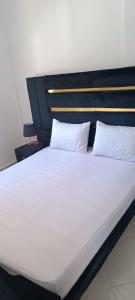 a large bed with white sheets and pillows at Le Nid d'azrou in Azrou