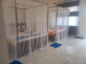 Un dormitorio con una cama con cortinas. en Sigiri Rock View Lodge, en Sigiriya