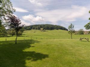 a bench in a field with a hill in the background at Ingleby Barn - 27946 in Battersby