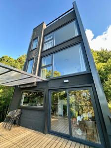 a house with large glass doors on a deck at Monolito, Pucón - Vista la lago y spa in El Cerrillo