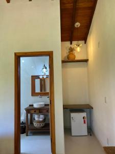 a hallway with a bathroom with a sink and a mirror at Chalés Pequena Floresta in Cunha