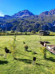 a field with a fence with mountains in the background at Cabañas Saiko in Futaleufú
