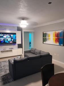a living room with a couch and a flat screen tv at Hartland Estate Richmond Priory in Priory