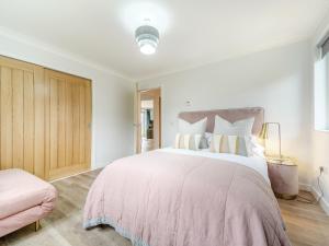 a white bedroom with a large bed with pillows at Springbank in Brodick