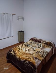 1 dormitorio con 1 cama con manta de estampado de tigre en Dúplex Sofía, en San Clemente del Tuyú