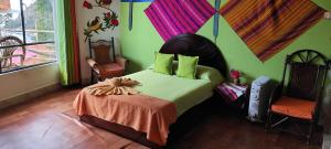 a bedroom with a bed and two chairs at Hostal Piedra Andina in Copacabana