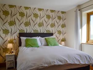a bedroom with a white bed with green pillows at Upper Close - Uk10873 in Evenjobb +8 photos