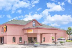 a pink building with a fast food restaurant at Super Motel in San Angelo
