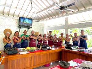 a group of people in a kitchen posing for a picture at Daphne Homestay & Cooking Class in Senggigi