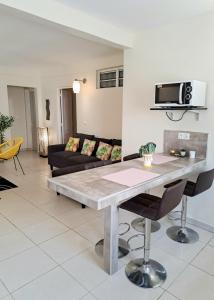 a living room with a table and a couch at T3 Serenity aux couleurs du soleil à Ducos in Ducos