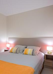 a bedroom with two pillows on a bed with two lamps at T3 Serenity aux couleurs du soleil à Ducos in Ducos