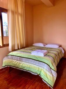 a bed sitting in a room with a window at Echevarria Oxapampa in Oxapampa +3 photos