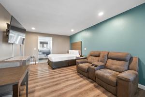 una sala de estar con un sofá y una cama en Hotel Milagro, en Chula Vista