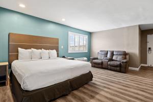 una habitación de hotel con una cama y una silla en Hotel Milagro, en Chula Vista
