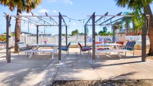 a picnic table and chairs under a pergola at Bella Sirena Inn in St Pete Beach