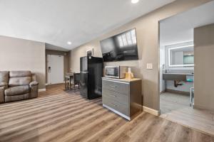 Una sala de estar con un sofá, un televisor y una mesa. en Hotel Milagro, en Chula Vista