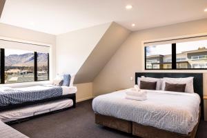 Dos camas en una habitación con dos ventanas. en Alpine Vista, en Lake Tekapo 18 fotos más