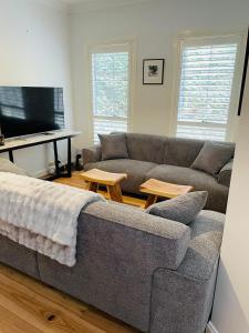 a living room with a couch and a flat screen tv at Bowral Retreat in Bowral