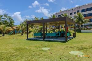 - un kiosque dans un parc à côté d'un bâtiment dans l'établissement Apartamento Cobertura em Guarajuba Perto do Mar, à Camaçari