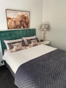 a bedroom with a large bed with a green headboard at Bowral Retreat in Bowral