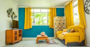 a living room with a yellow couch and a table at Plage privée - Vahine Ori Lodge in Raiatea