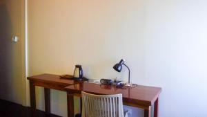 a wooden desk with a lamp and a chair at Hidden Gardens Resort, Davao in Davao City