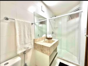 ein Badezimmer mit Waschbecken und Glasdusche in der Unterkunft Suites da Manu in Morro de São Paulo