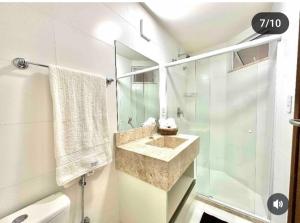 ein Badezimmer mit Waschbecken und Glasdusche in der Unterkunft Suites da Manu in Morro de São Paulo