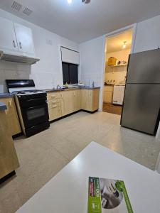 an empty kitchen with a refrigerator and a stove at Campbelltown Family Retreat 3-Bedroom Home in Campbelltown