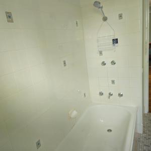 a white bathroom with a tub and a shower at Campbelltown Family Retreat 3-Bedroom Home in Campbelltown