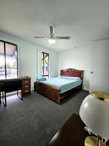a bedroom with a bed and a table and a desk at Campbelltown Family Retreat 3-Bedroom Home in Campbelltown +32 photos