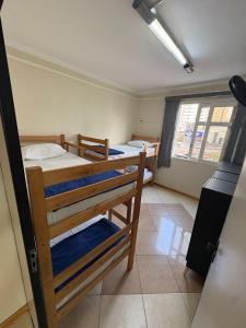 a dorm room with three bunk beds in it at AS Pousada Alojamento in Sao Jose do Rio Preto
