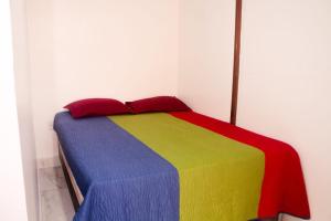 a bed with a multicolored blanket in a room at Casa com suítes e café da manhã in Belém