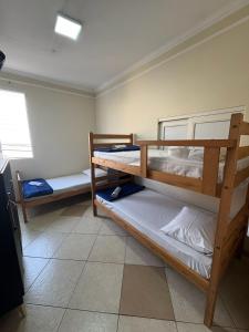 a bedroom with two bunk beds and a window at AS Pousada Alojamento in Sao Jose do Rio Preto