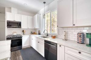 a white kitchen with white cabinets and a sink at Stay Portland - Brand New Luxury Mt Hood Cabin in Rhododendron