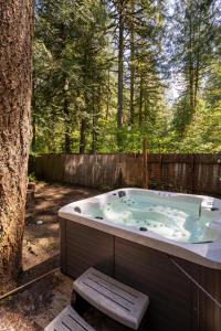 a hot tub in a yard next to a tree at Modern A-Frame Cabin in the Woods in Rhododendron
