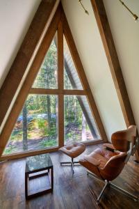 a room with a large window and two chairs and a table at Modern A-Frame Cabin in the Woods in Rhododendron