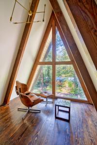 a room with two chairs and a large window at Modern A-Frame Cabin in the Woods in Rhododendron +24 photos