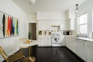 a kitchen with white cabinets and a small table at The Art Deco Lounge - 95 WalkScore - Live Music in Portland