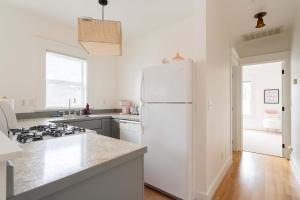a kitchen with a white refrigerator and a stove at The Bohemian Spirit - Live Music, Eateries & Bars in Portland +25 photos