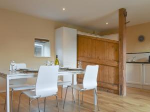 a kitchen with a white table and white chairs at Kildale Barn in Kildale