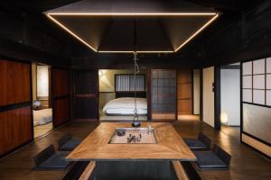 Habitación con mesa y cama en el fondo en MAHORA西野谷 古民家宿 Myoko Taditional Japanese house, en Myoko