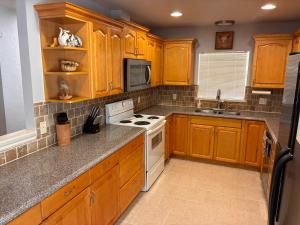 a kitchen with wooden cabinets and a white stove top oven at Paradise on the Prairie in Oklahoma City