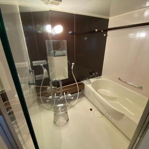 une salle de bain avec un lavabo et un miroir dans l'établissement 一棟貸し宿月灯草津, à Kusatsu