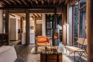 a living room with a glass table and a chair at Dali Ancient City Xishan Designer Hotel in Dali Ancient Town