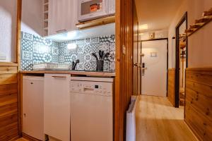 a kitchen with a dishwasher and a washer at Ski in and out heart of Val Thorens - 1BR Sleeps 4 people in Val Thorens