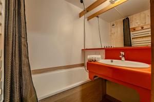 a bathroom with a sink and a bath tub at Ski in and out heart of Val Thorens - 1BR Sleeps 4 people in Val Thorens