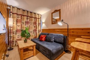 a living room with a couch and a table at Ski in and out heart of Val Thorens - 1BR Sleeps 4 people in Val Thorens